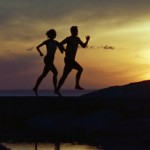 Couple Running Near Water At Sunset, Silhouette